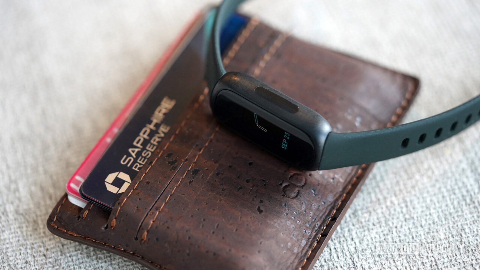 Fitbit Inspire 3 Wallet A Fitbit Inspire 3 rests on a users wallet.